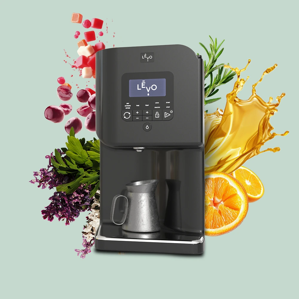 The LĒVO machine cut out on a sage ground, surrounded by gummies, cherries, purple herbs, rosemary, orange slices and a splash of golden oil.